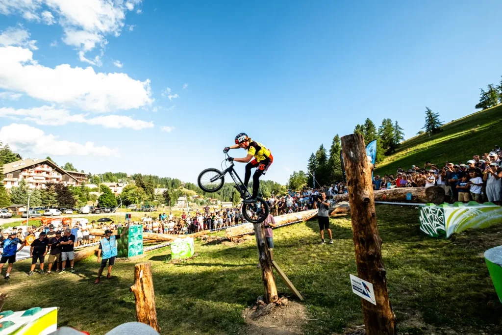 Photo de la coupe de france de VTT Trial, ou l'on voit un cycliste sur le haut d'un tronc, dans le parcours